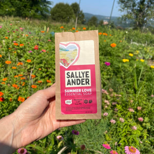 Summer Love Essential Soap in front of outdoor flower field.
